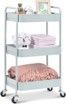 A white cart with three shelves and wheels filled with towels and blankets.