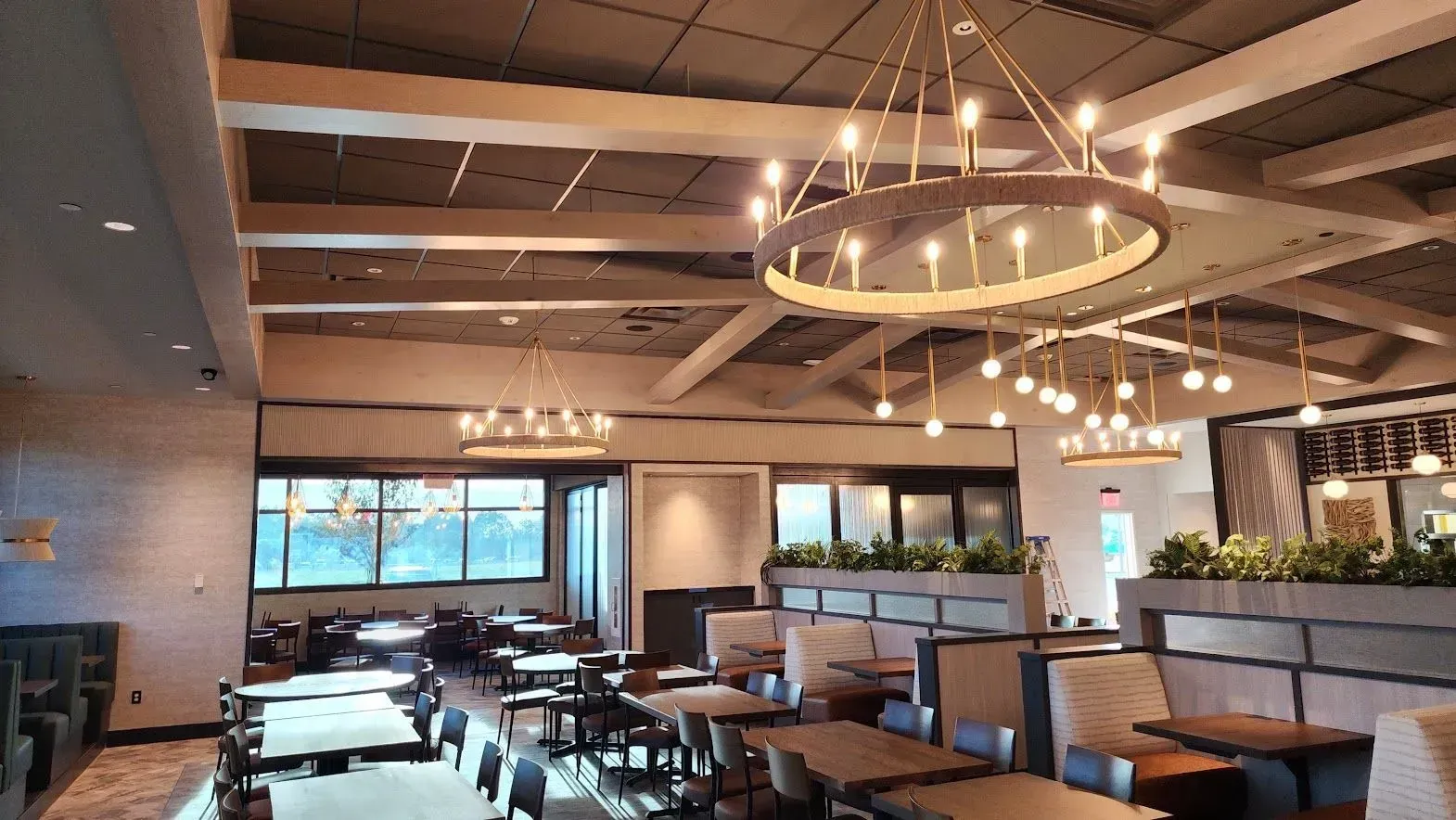 A restaurant with tables and chairs and a chandelier hanging from the ceiling.