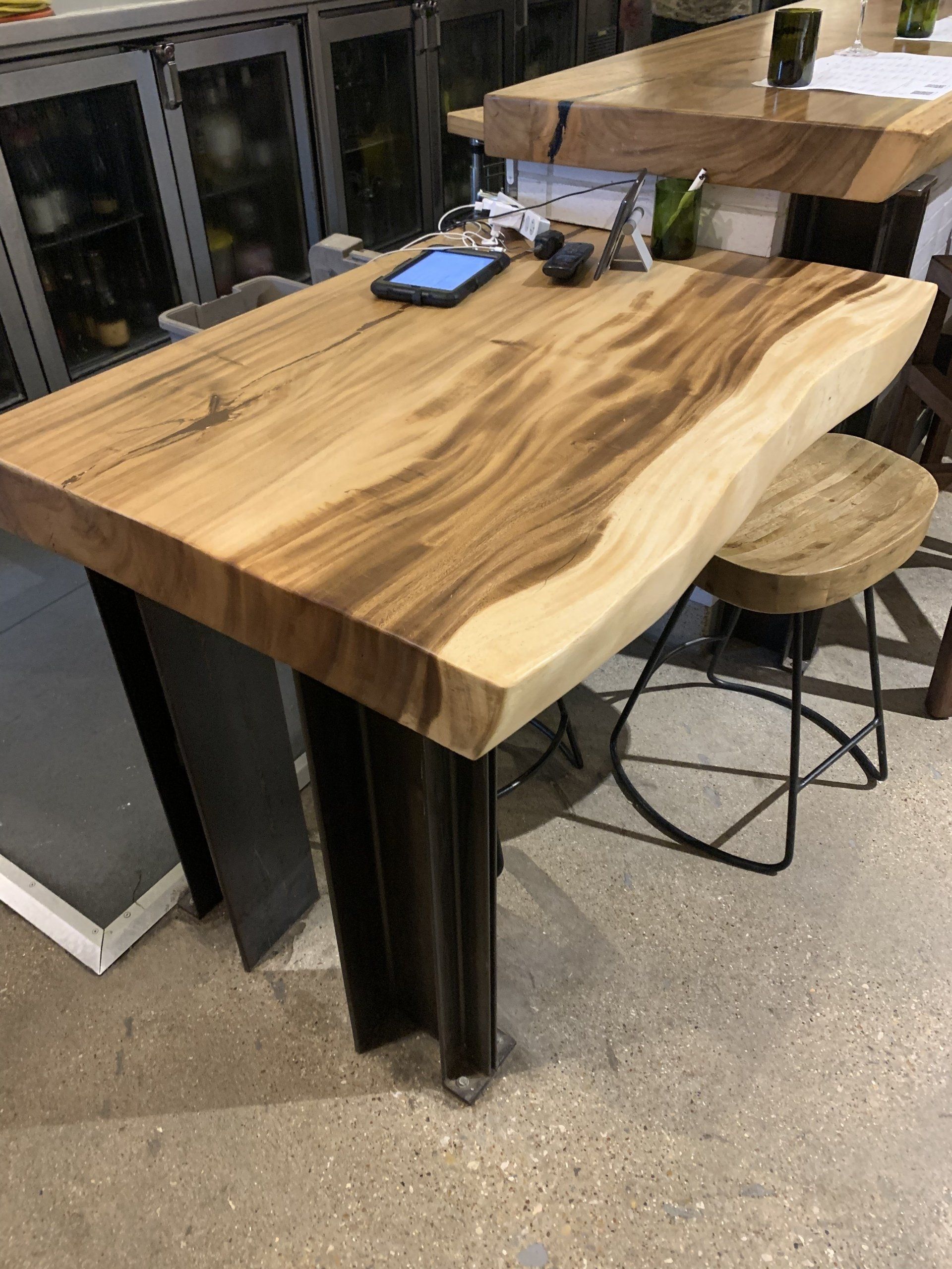 A wooden table with a cell phone on top of it.