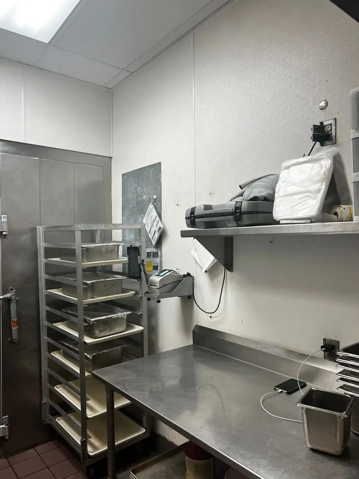 A kitchen with a stainless steel table and shelves.