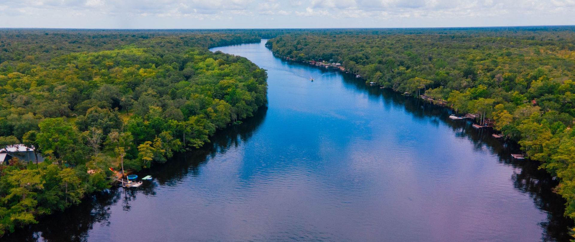 An aerial view of a river surrounded by trees.