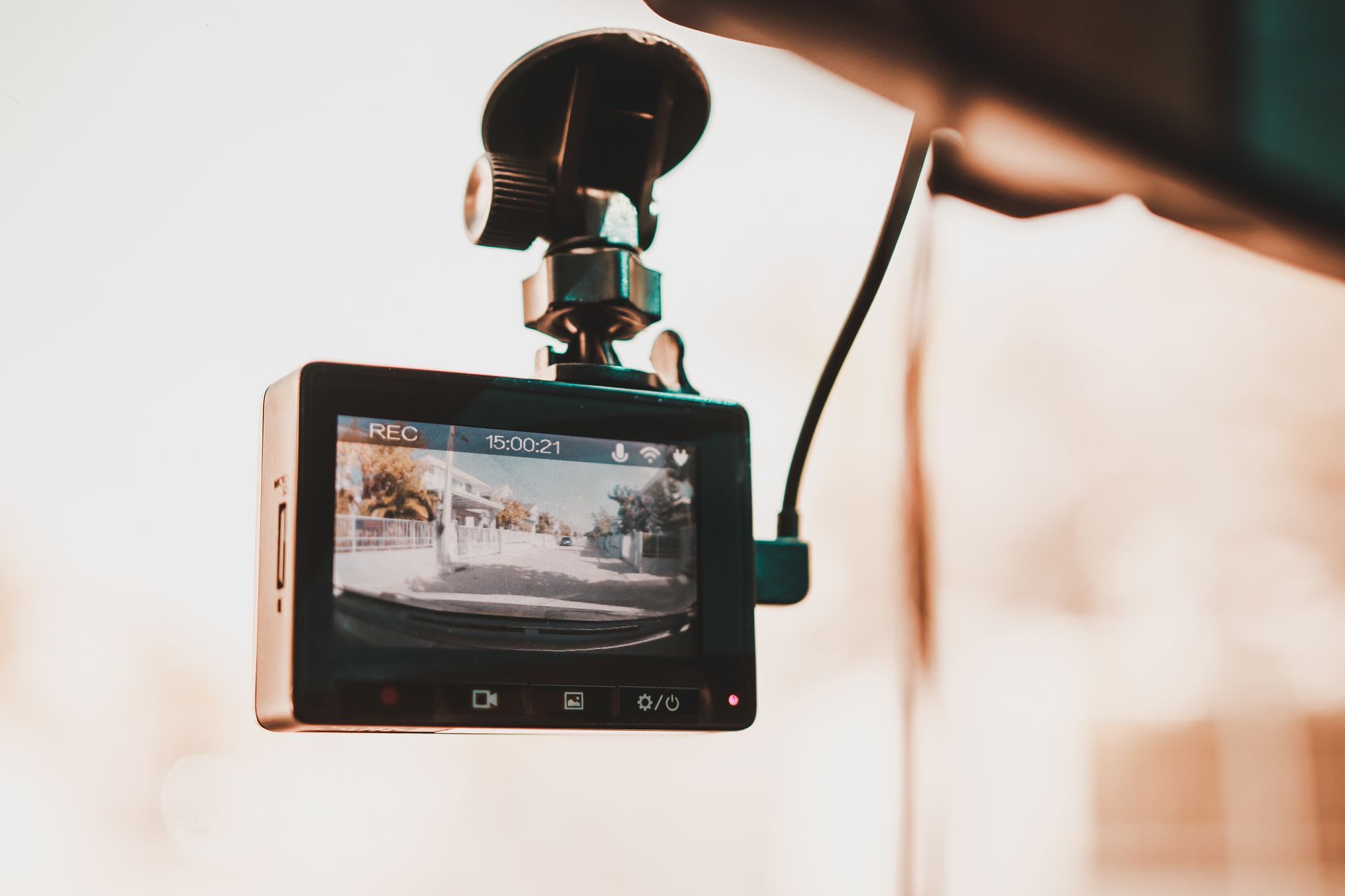 Dashboard camera mounted on a windshield, recording the road ahead in daylight