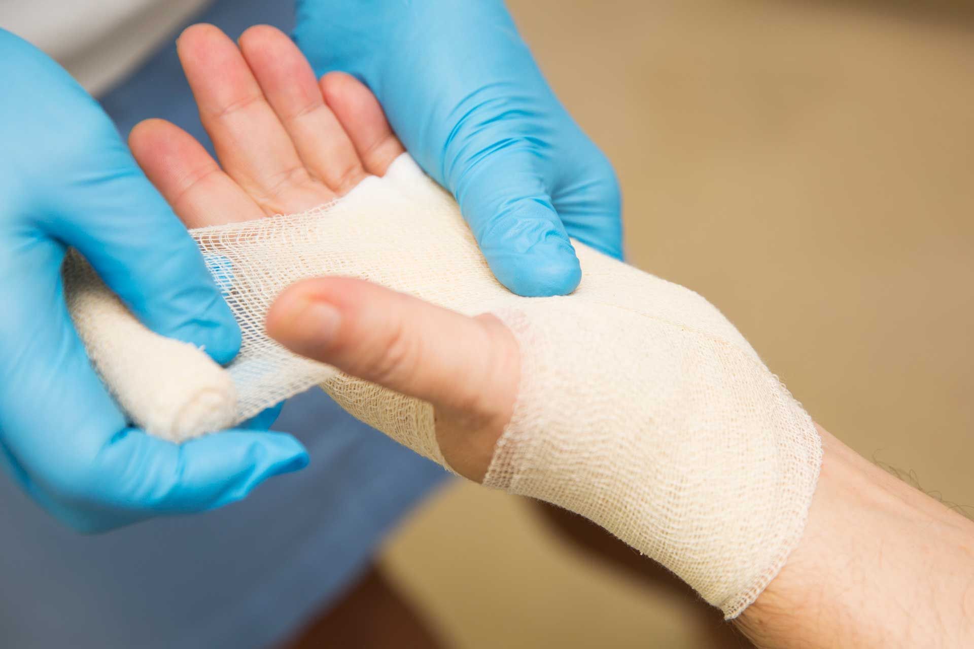 A person is getting a bandage on their hand.