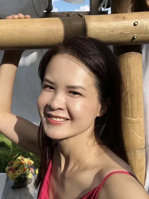 CP 穿紅色細肩帶上衣在竹架旁笑