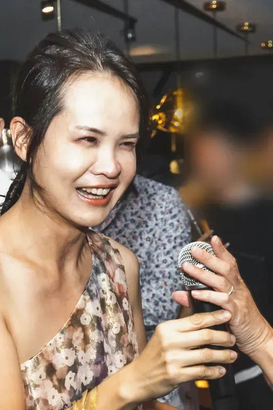 CP 穿花色單肩洋裝，在生日派對上拿著麥克風大笑