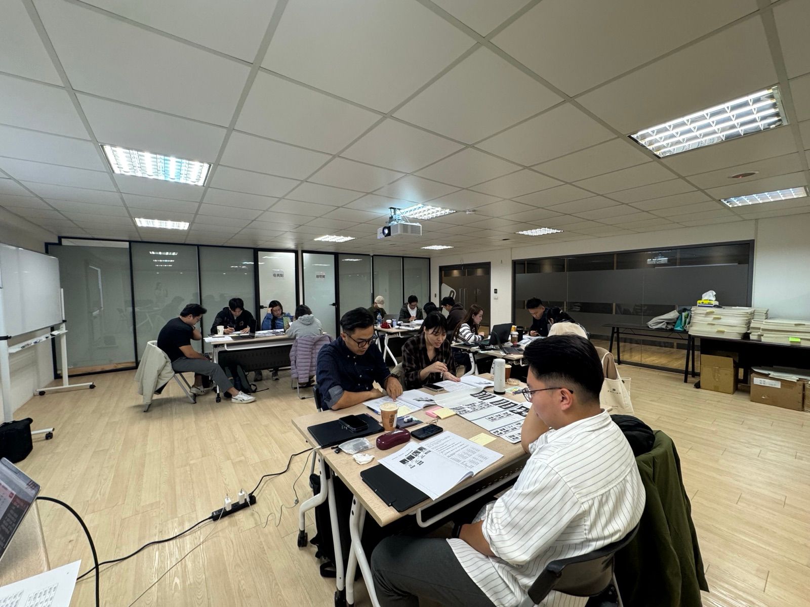 男學員圍著 2 張桌子一起實作