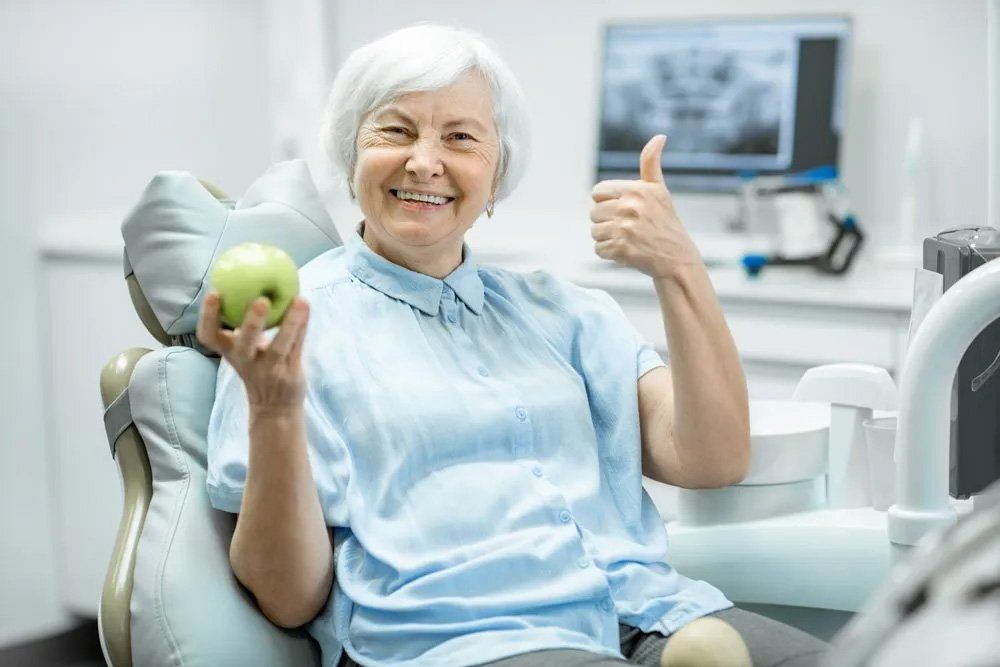Patient Holding an Apple — Amherst, OH — Gregory Sy, DDS