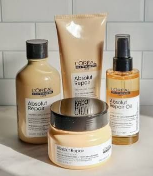 Haarverfproducten en -tools op een kaptafel. L'Oréal-spiegel met een persoon op de achtergrond.