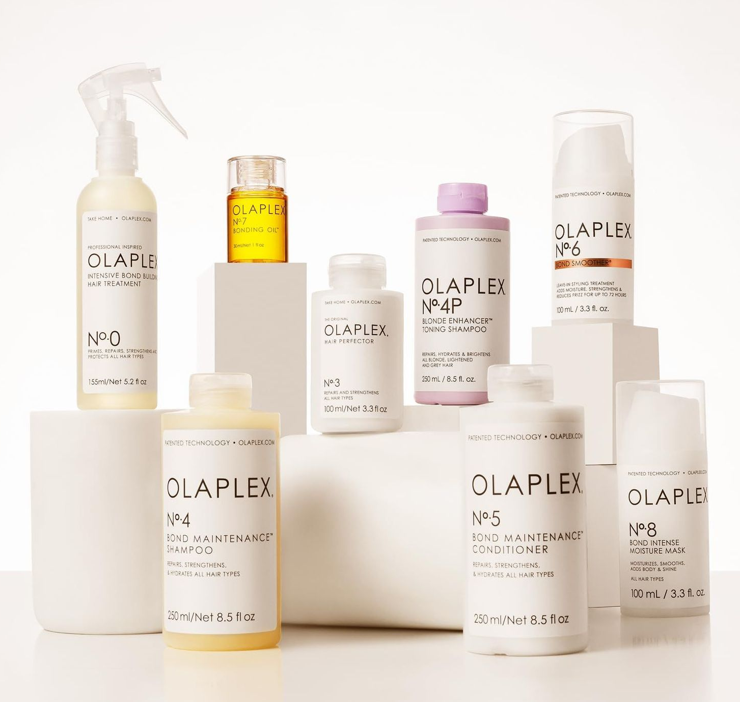 Fles Olaplex No. 4 Bond Maintenance Shampoo in zeepwater met roze tinten.