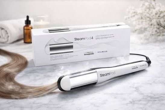 Haarstylingtools en -producten op een donkere ondergrond. Inclusief een stijltang, stylingcrème en serum.