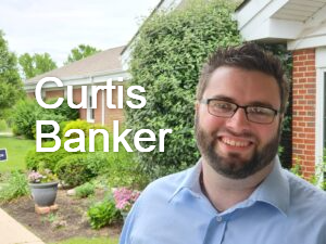 Curtis Banker, pastor, is smiling in front of Hanfield GMC.
