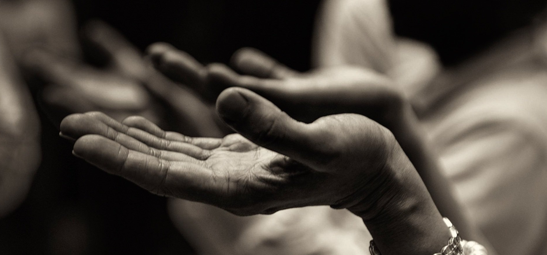 A person is holding their hands out in a black and white photo.