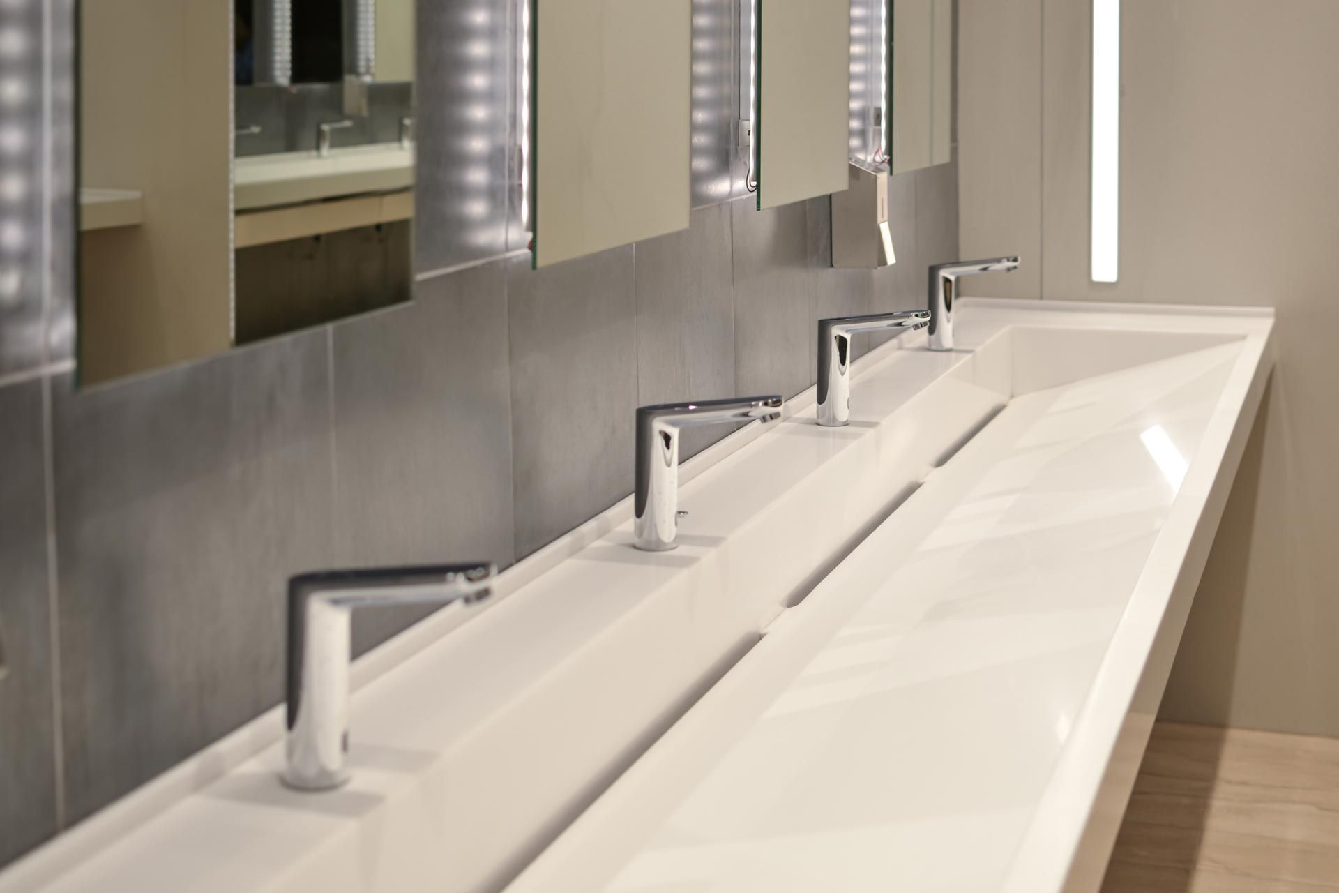 Modern bathroom with two white sinks, chrome faucets, and mirrors on a gray wall