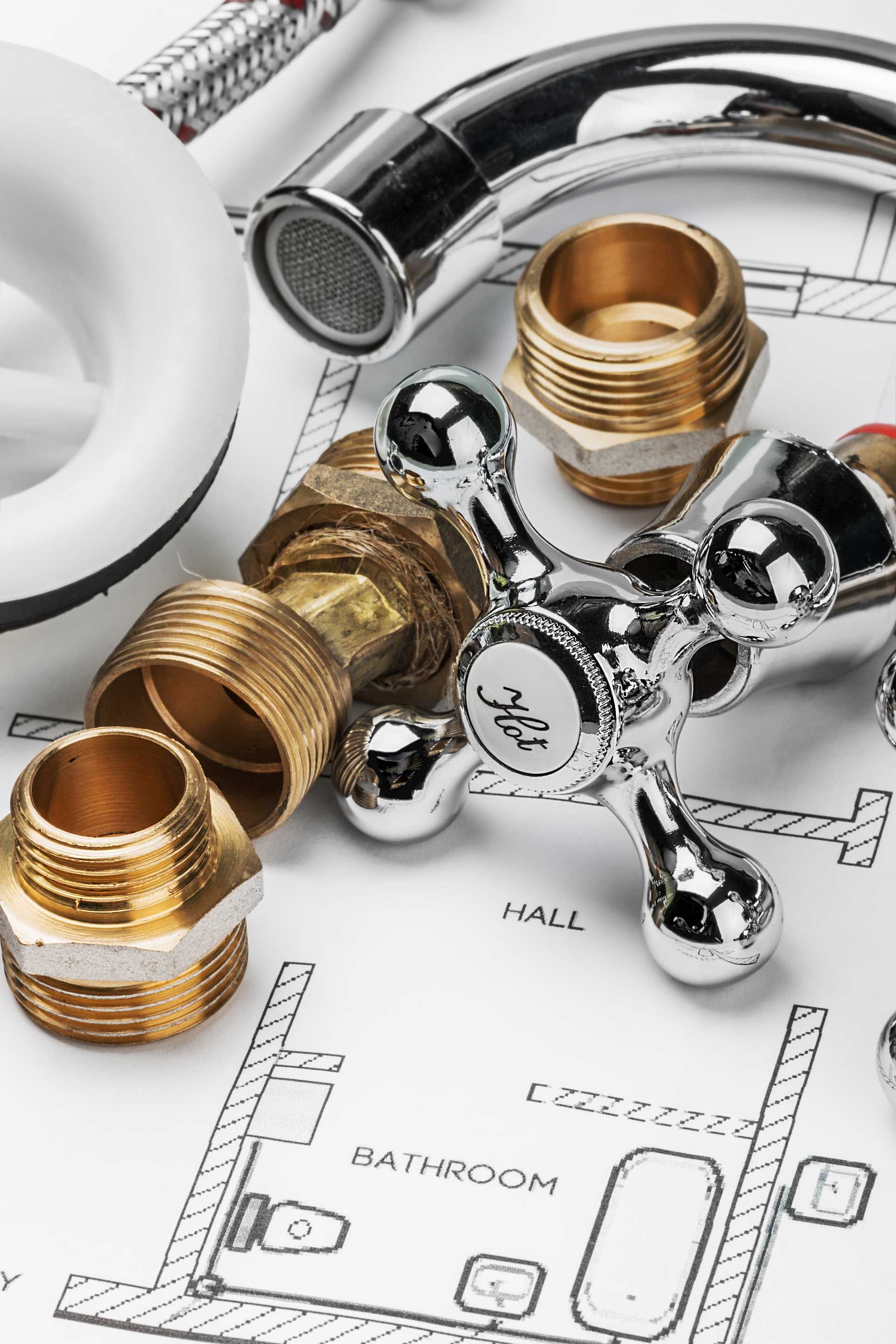 Plumbing fixtures and brass fittings on a bathroom sink installation blueprint
