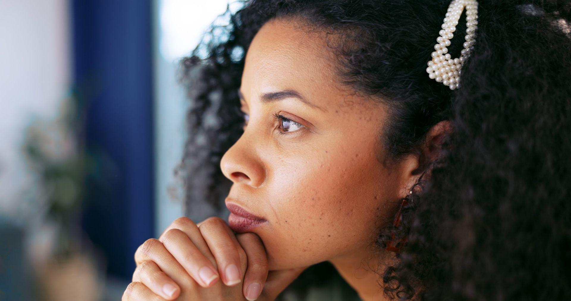 Woman with clasped hands thinking contemplatively after EMDR therapy