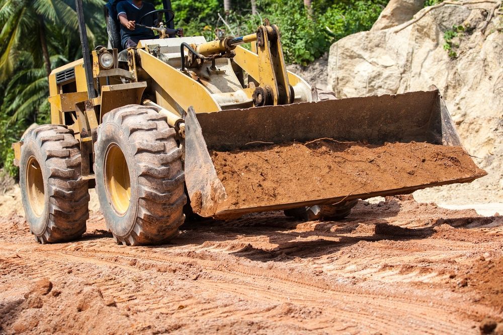 Yellow Bulldozer Pushing Dirt on a Construction Site — Northern Heavy Machinery in Mount Louisa, QLD