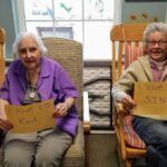 Two elderly women holding signs,