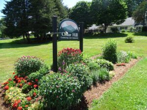 Cedar Hill sign with a colorful flower garden in front.