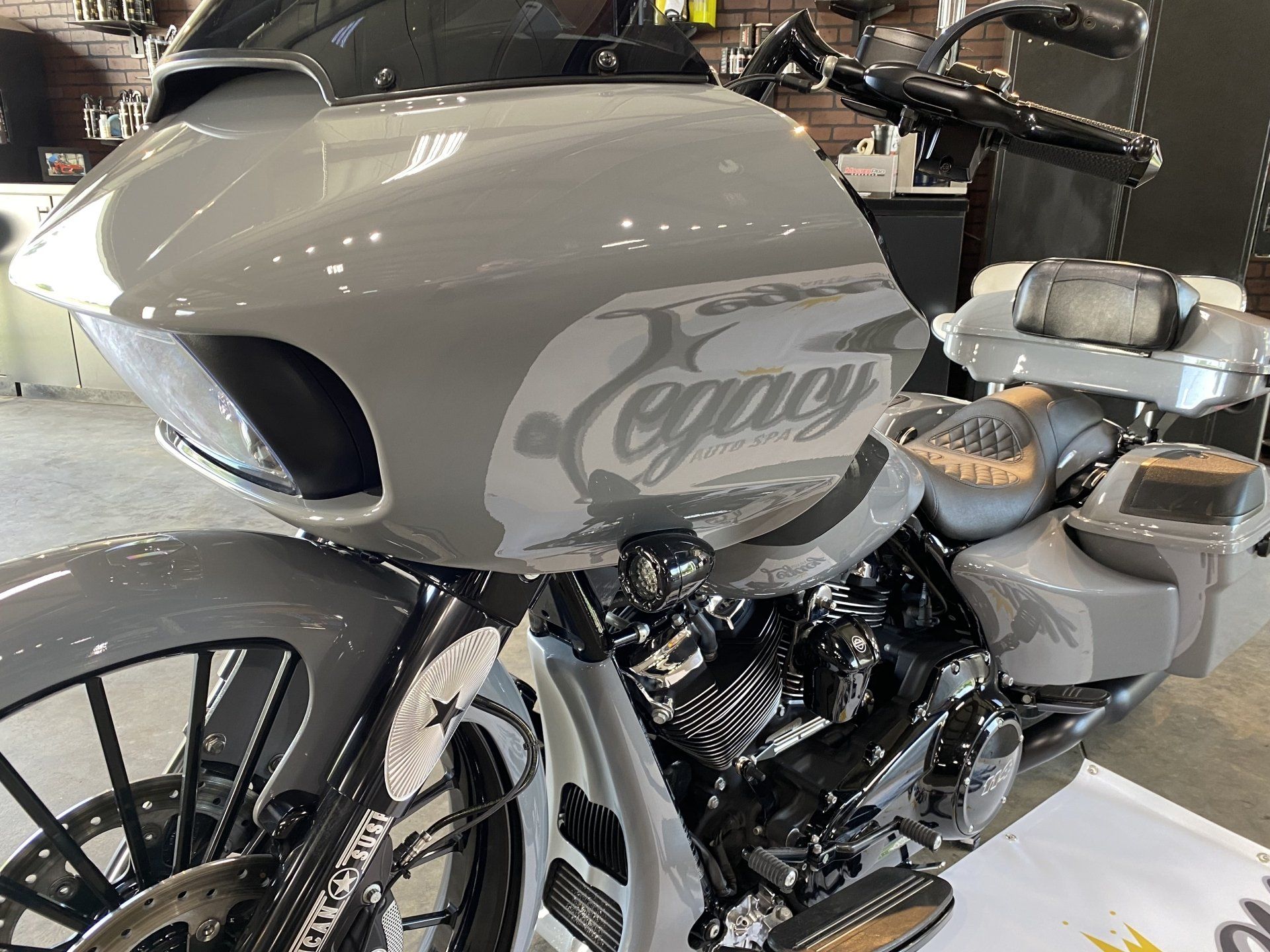 Gray custom motorcycle with a large front fairing and “Cognac” logo, parked indoors