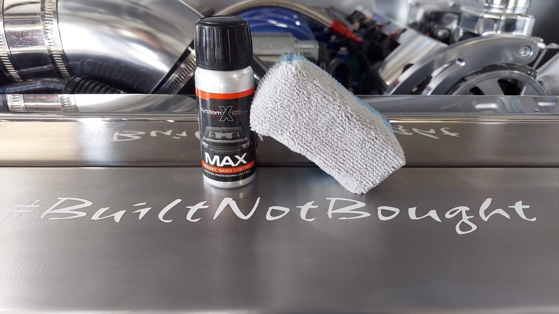 Car cleaning spray bottle and microfiber cloth on a car hood with “I can’t not bought” written in soap