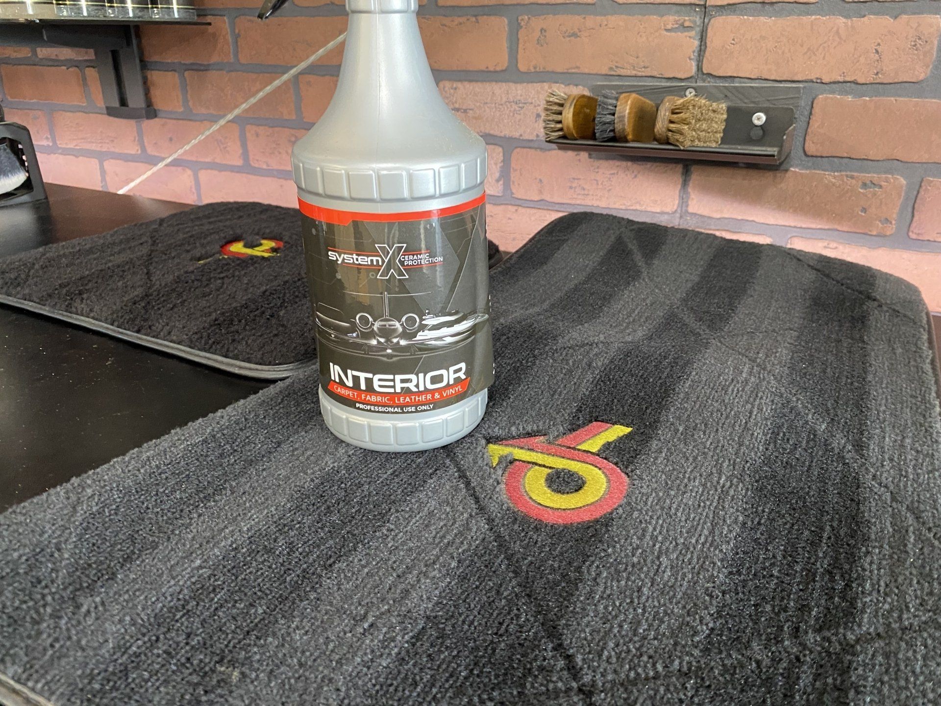 Bottle of Interior cleaner on a dark countertop with brick backsplash and electrical outlets nearby