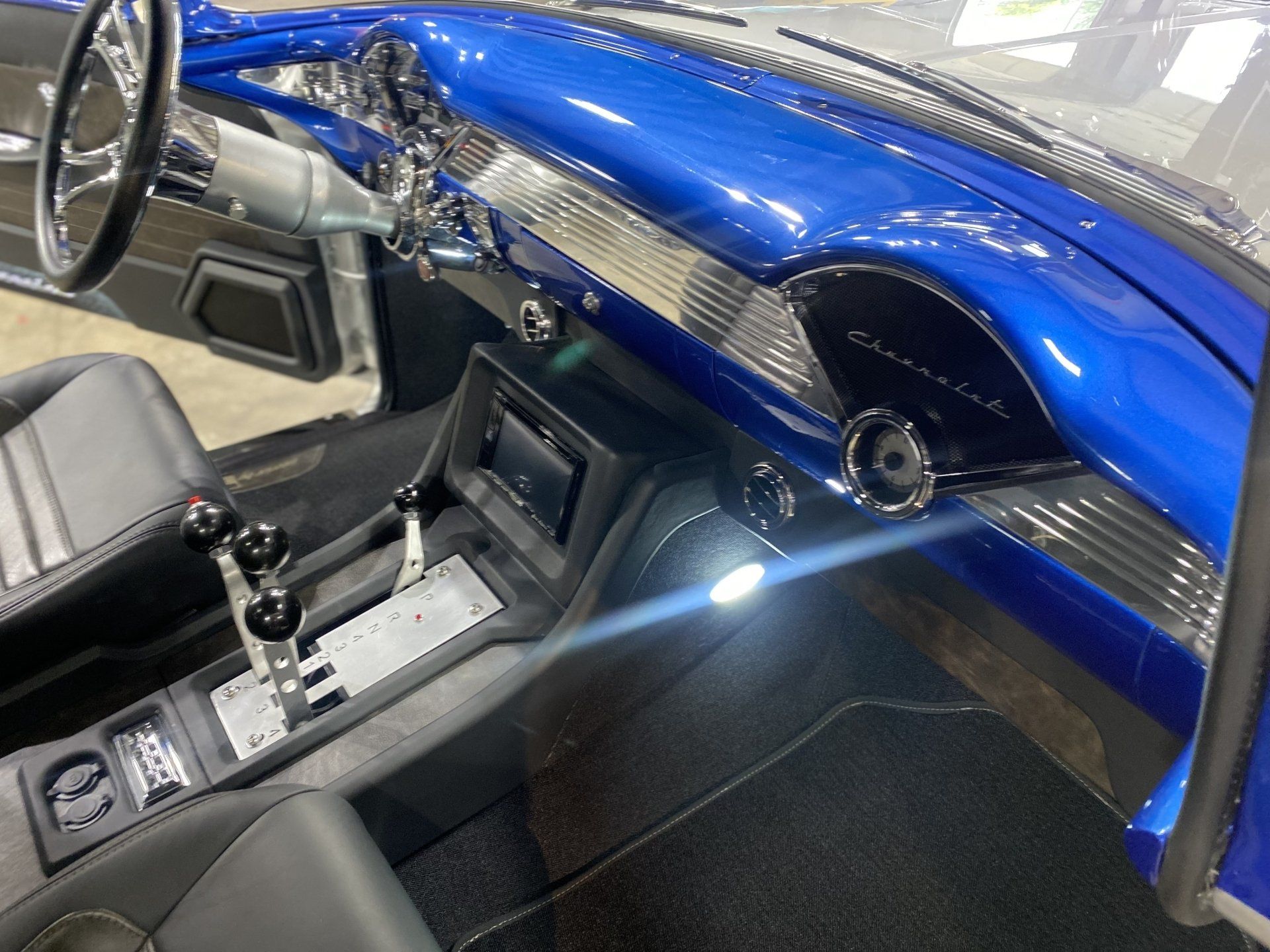 Blue custom car interior with carbon fiber dashboard, center console, and steering wheel