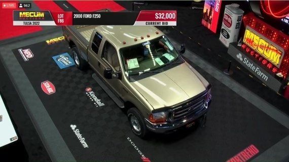 Tan pickup truck on a display platform at an indoor auto show, viewed from above