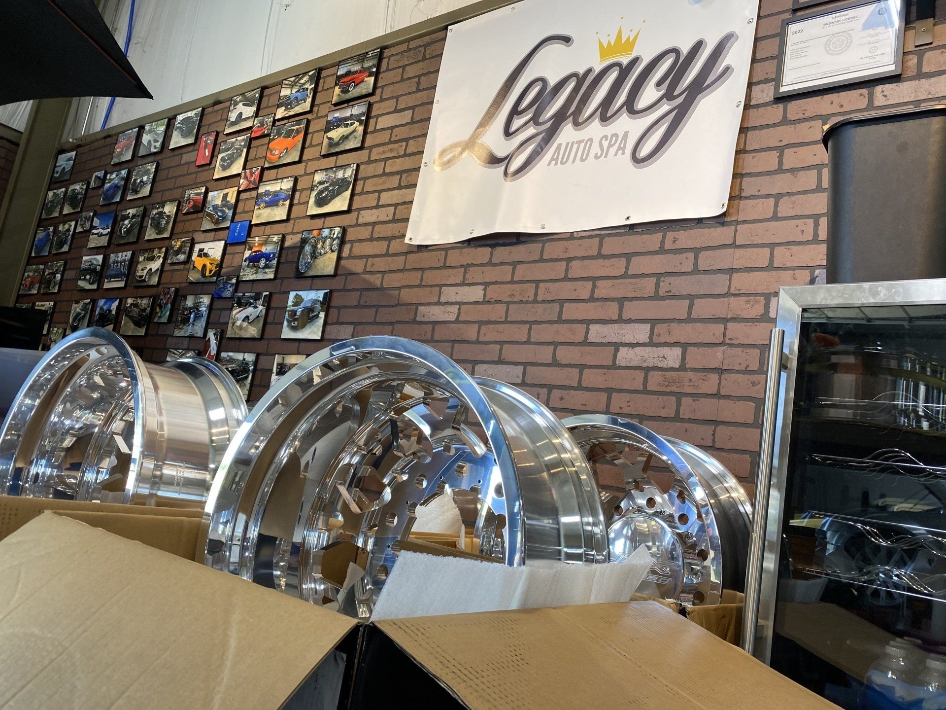 Chrome serving trays on a counter inside a shop with a brick wall and “Legacy” sign