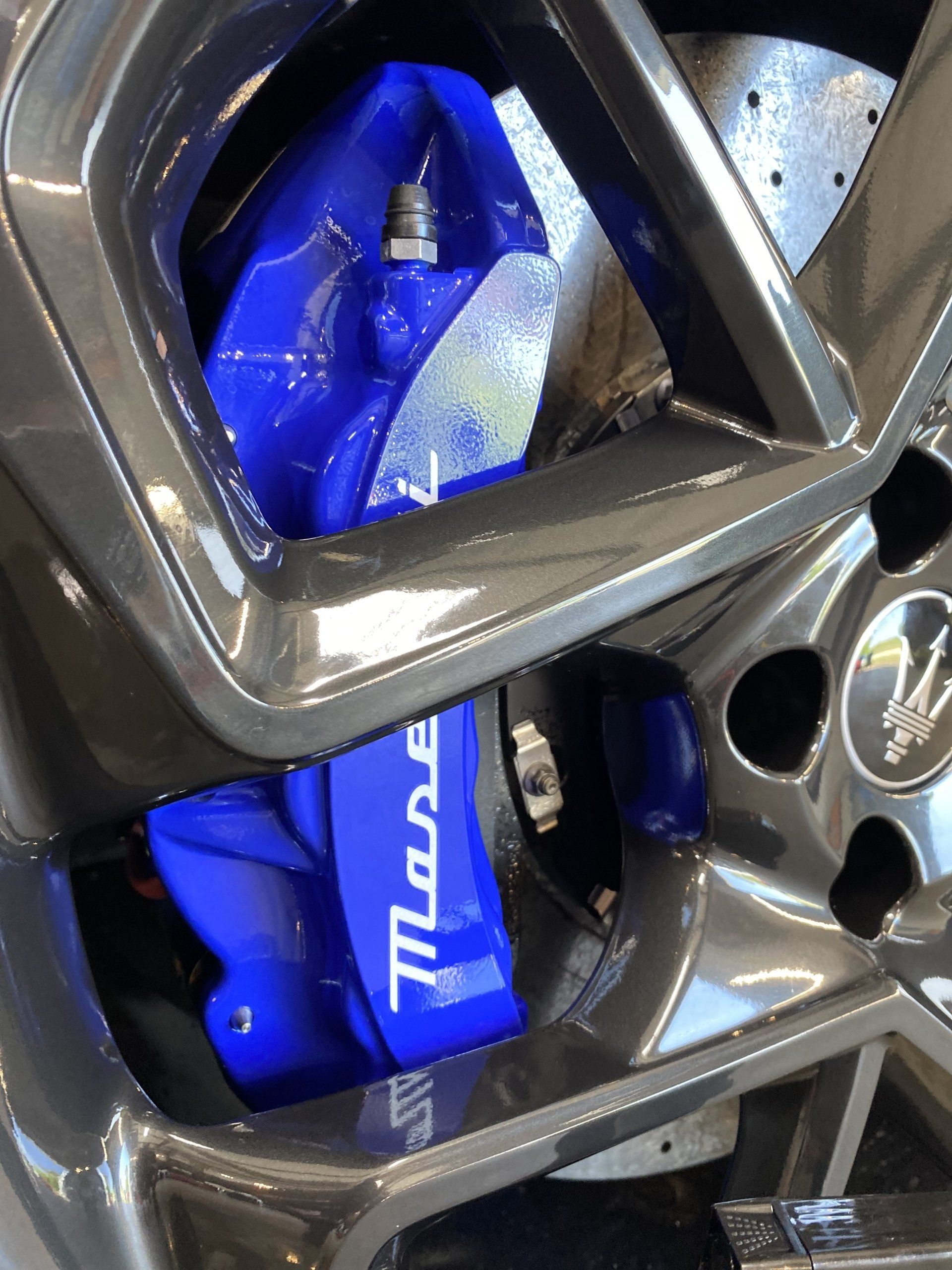 Blue Wilwood brake caliper behind a silver alloy wheel rim