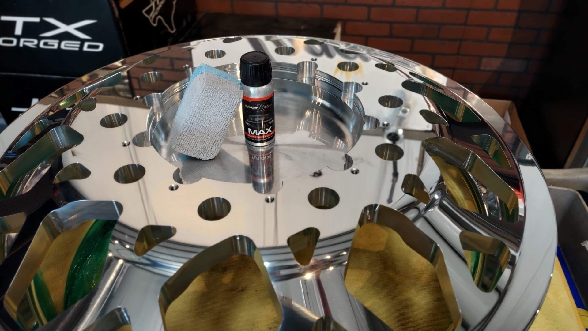 Shiny round display table with a central spray can and gold leaf samples around the edge