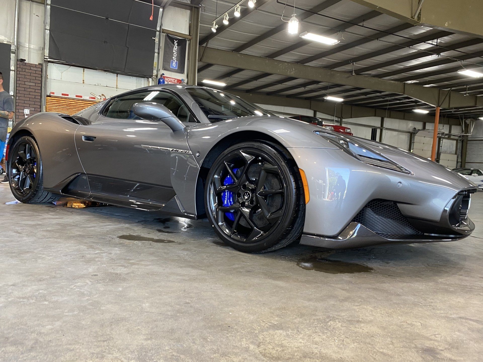 Gray sports car with blue brake calipers parked in a garage
