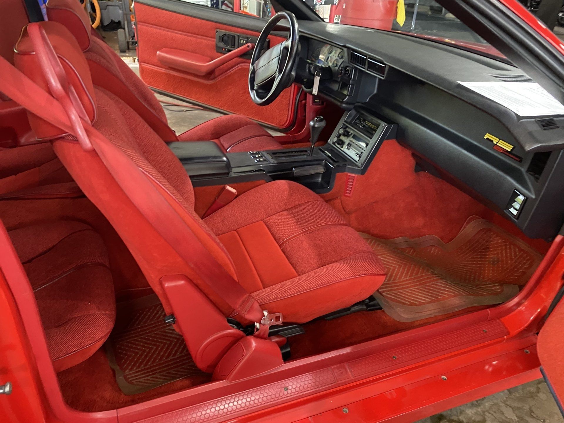 Red vintage car interior with red bucket seats and black dashboard