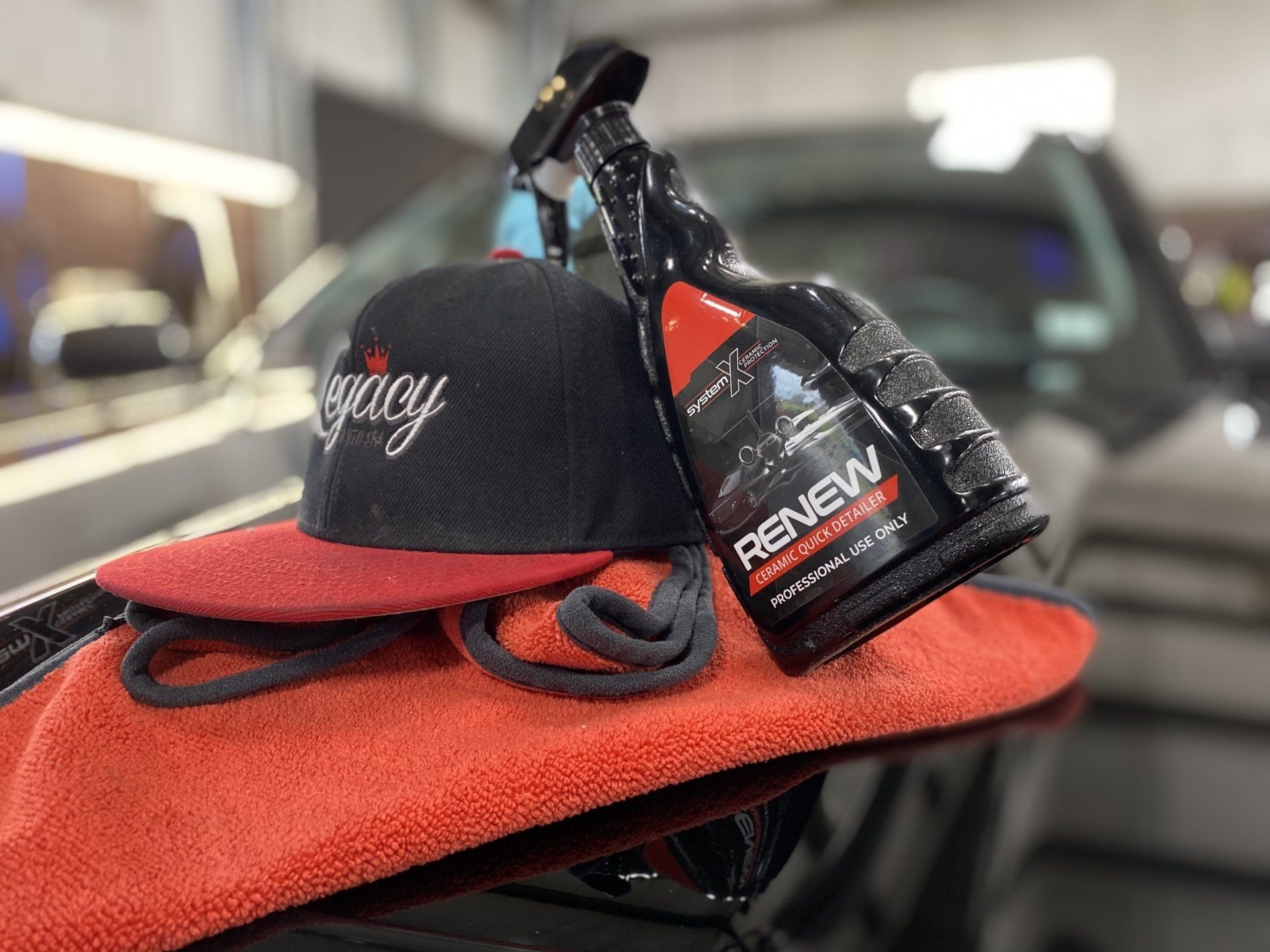 Black cap and red towel on a table with a spray bottle in the background
