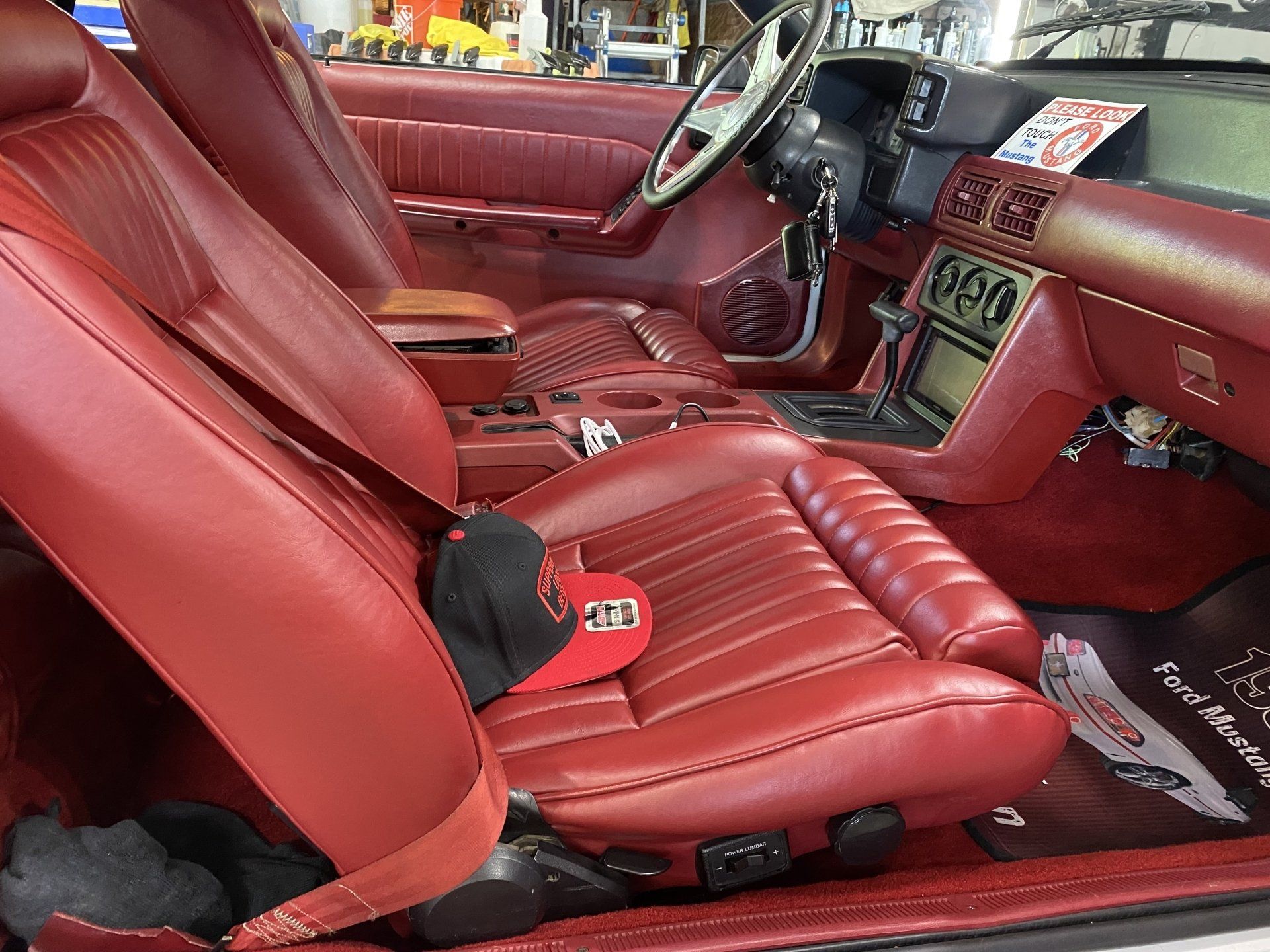 Red leather car interior with custom seats, steering wheel, and dashboard console