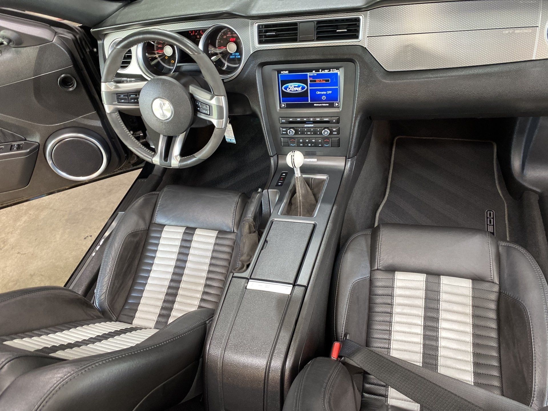 Custom car interior with black leather seats, striped inserts, and blue-lit center console