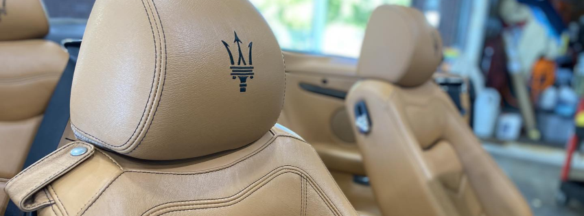Tan leather Maserati car seats with headrests and logo in a luxury interior