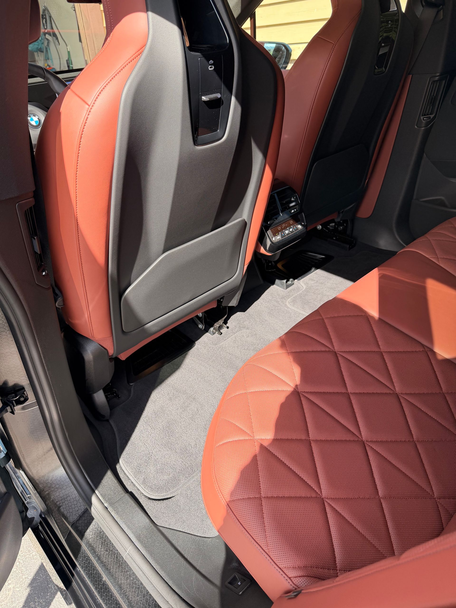 Car interior with red-and-black quilted seats and a gray center console area