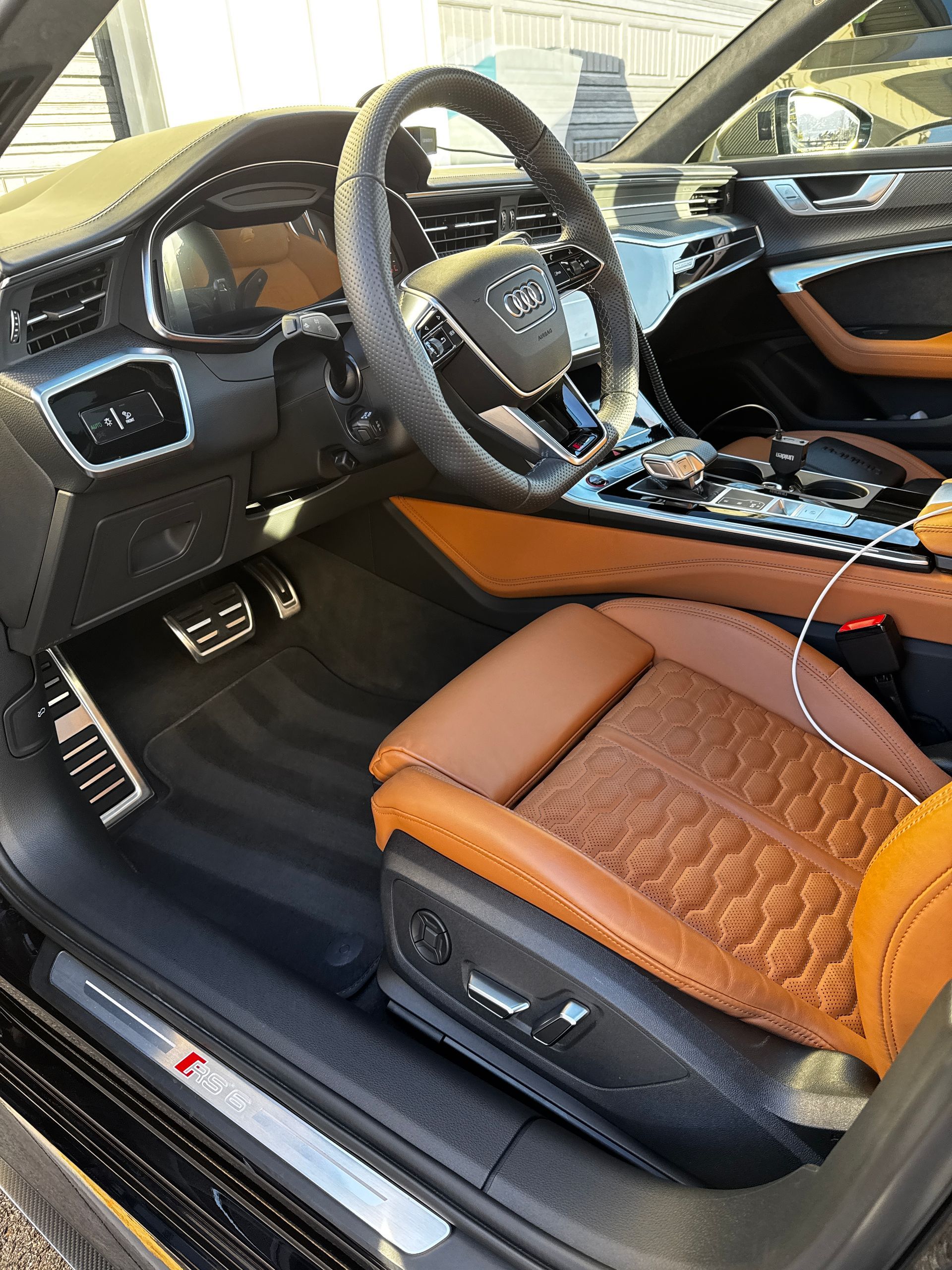 Luxury sports car interior with tan leather seats, black dashboard, and silver trim