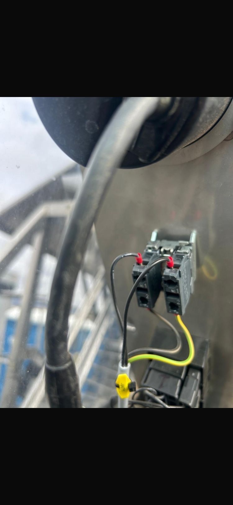 Electrical junction box with wires connected. Black and yellow wires against a gray surface.