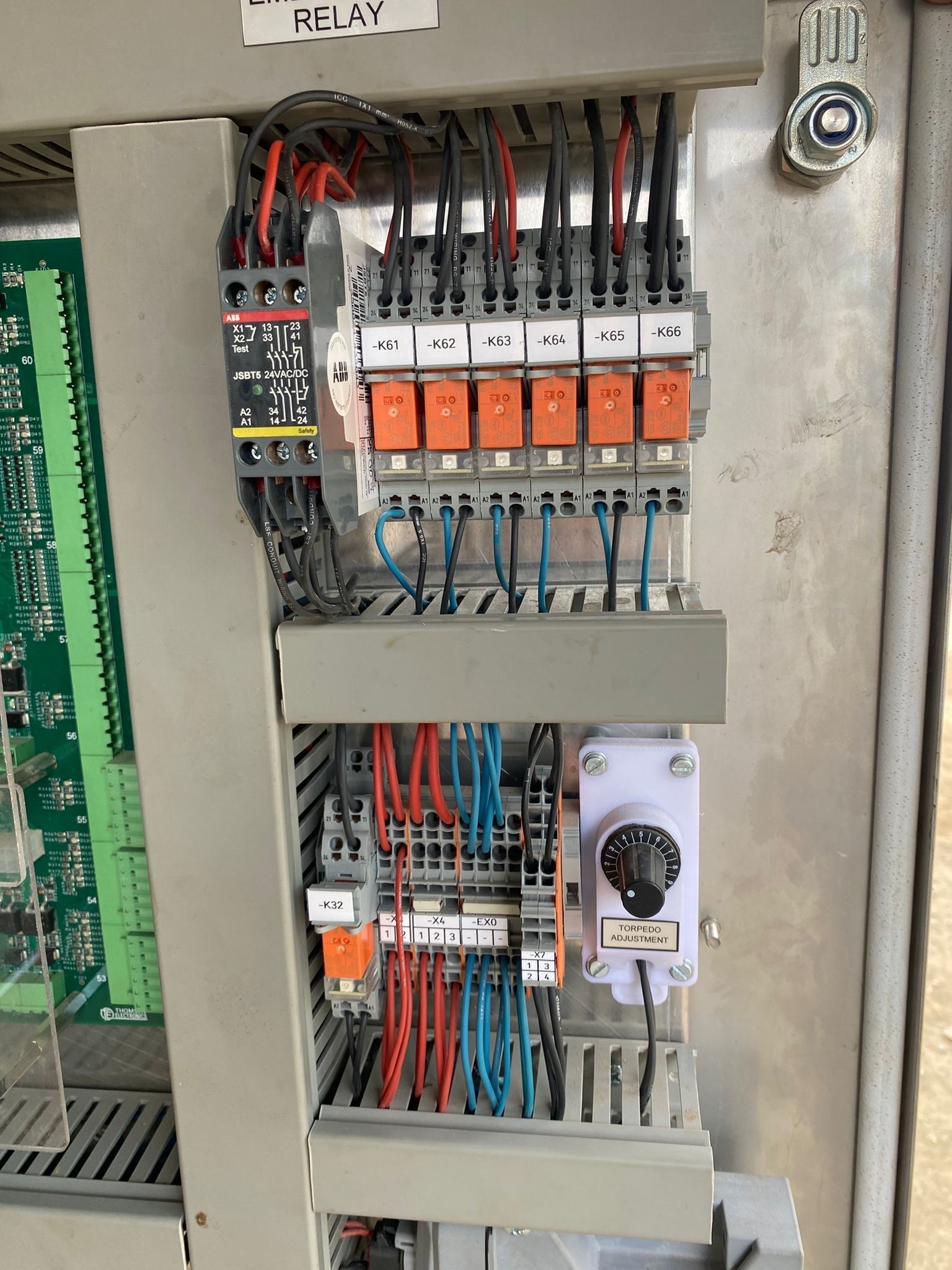 An electrical control panel with wires, relays, and a circuit board.