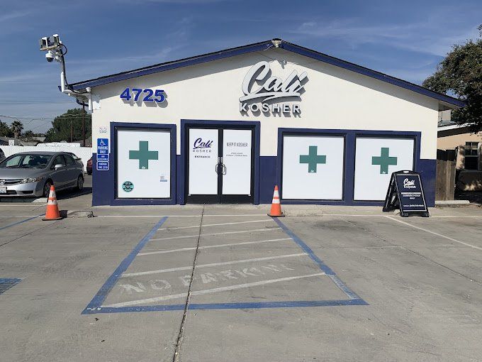 Front exterior of Cali Kosher’s Modesto dispensary with accessible parking and entrance signage.