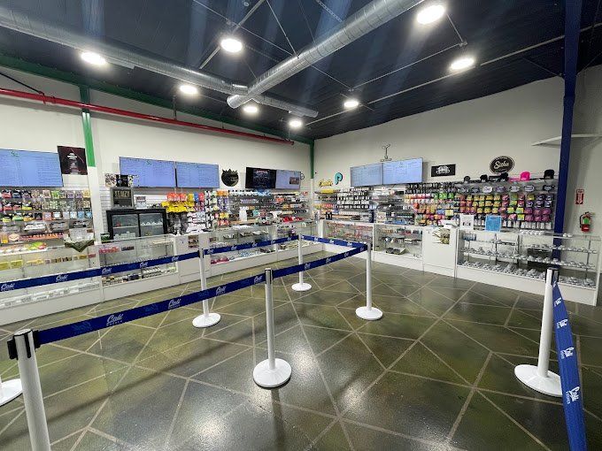 Interior of Cali Kosher’s Oakdale dispensary with glass display cases, product shelves, and digital menu screens.