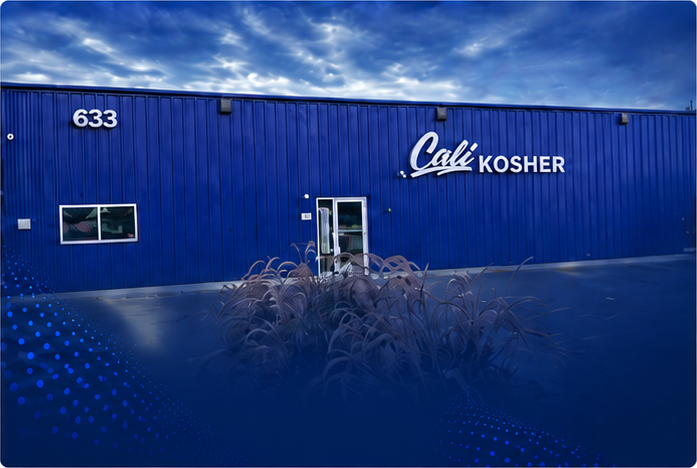 Exterior of Cali Kosher’s Oakdale dispensary, featuring a dark blue facade, storefront sign, and parking area.