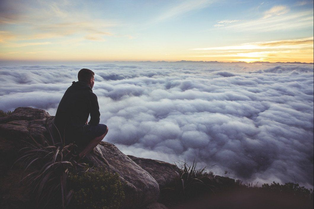 Man on Top of the Mountain Looking at the Clouds