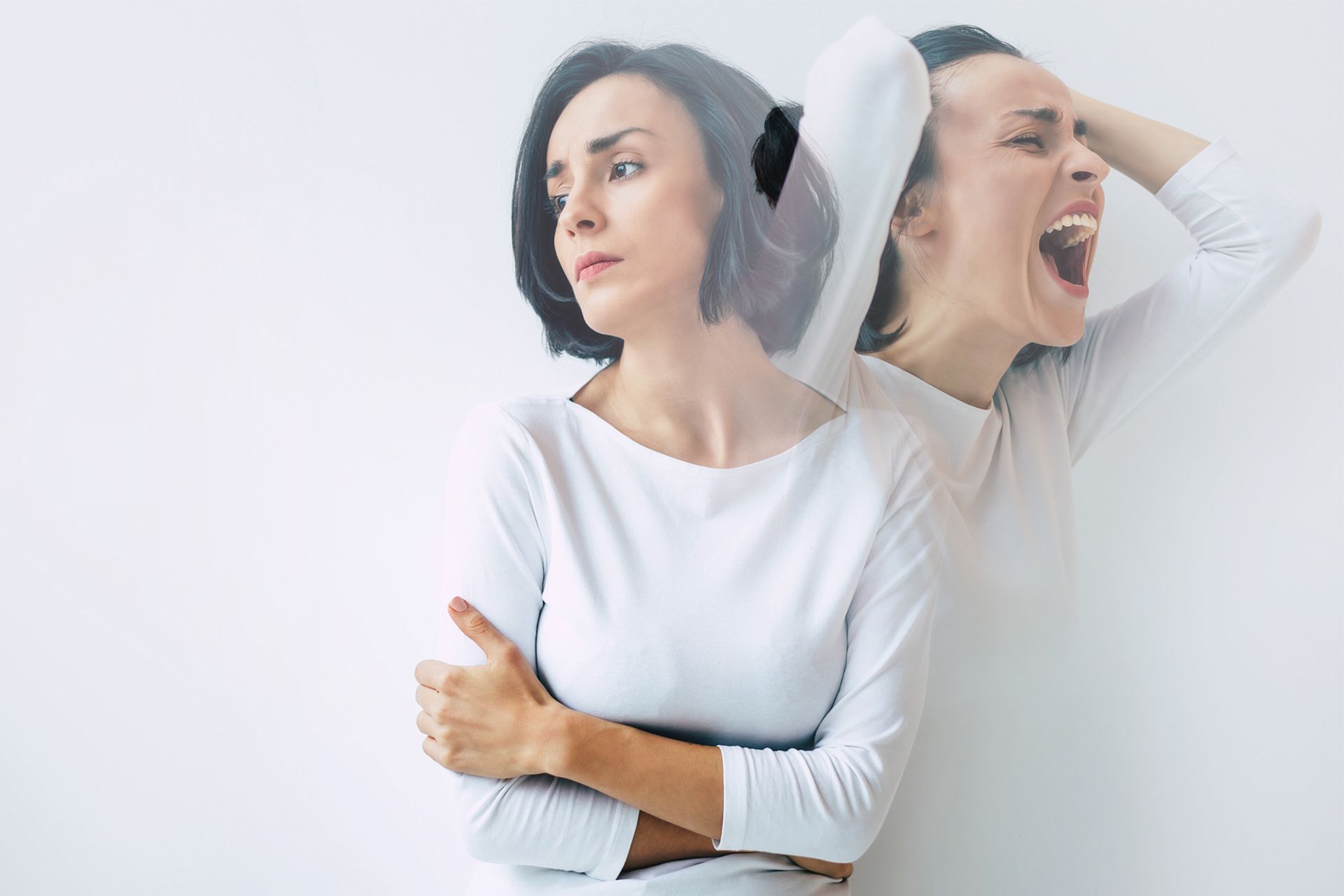 Woman showing calm and angry emotions simultaneously, one side contemplative, other side screaming.