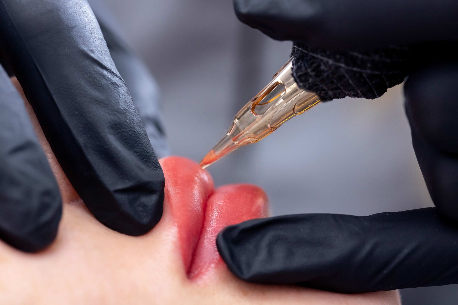 a close up of a person getting a tattoo on their lips