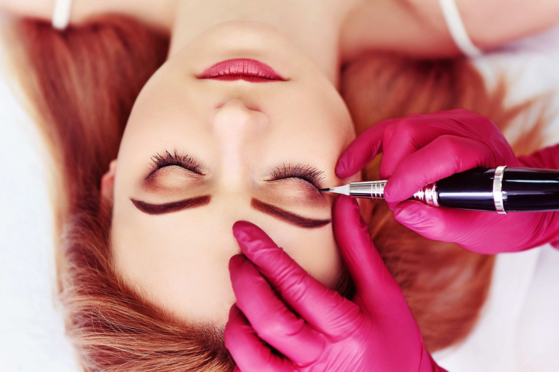 a woman is getting a tattoo on her eyebrows