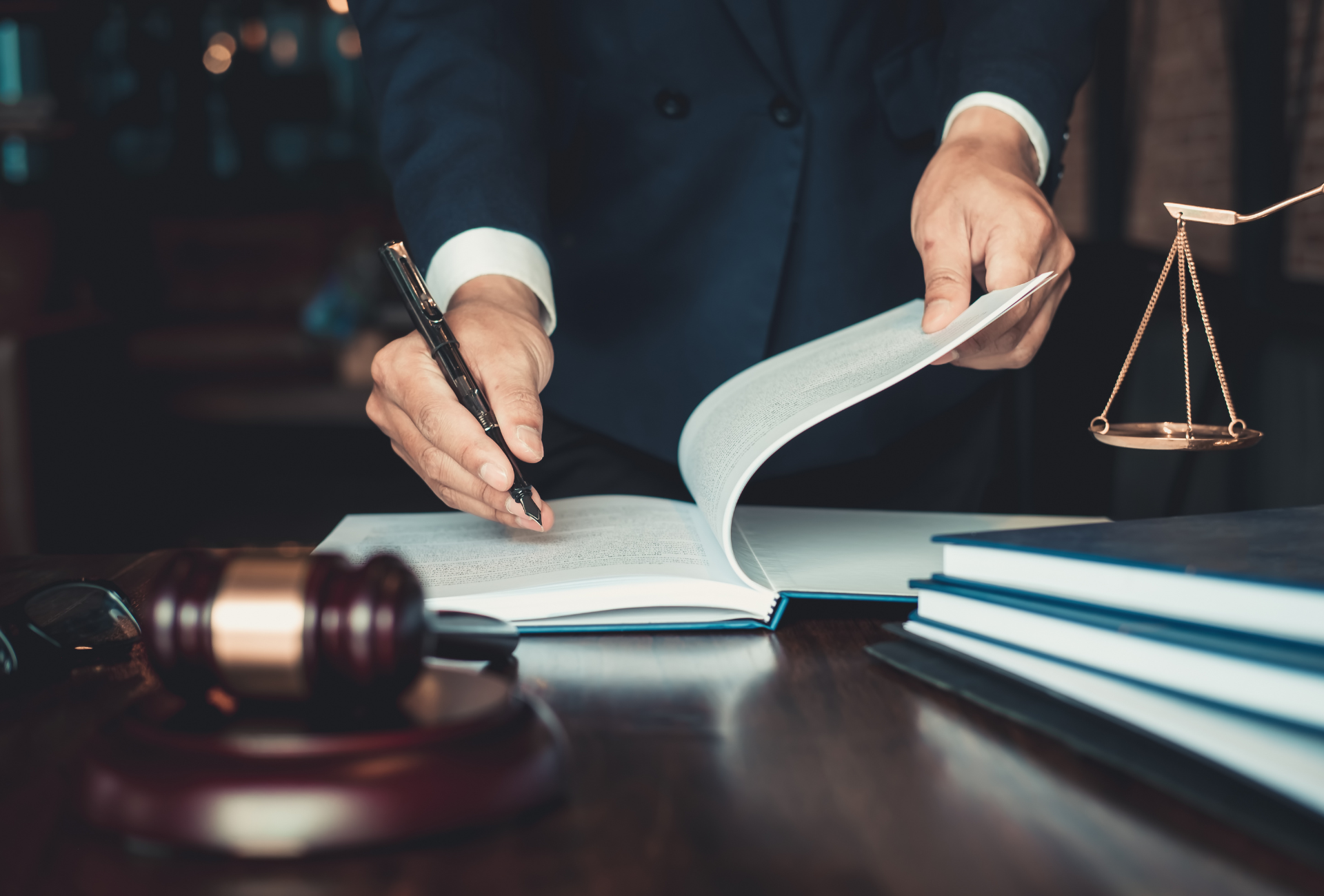 a lawyer is writing on a piece of paper while sitting at a desk .