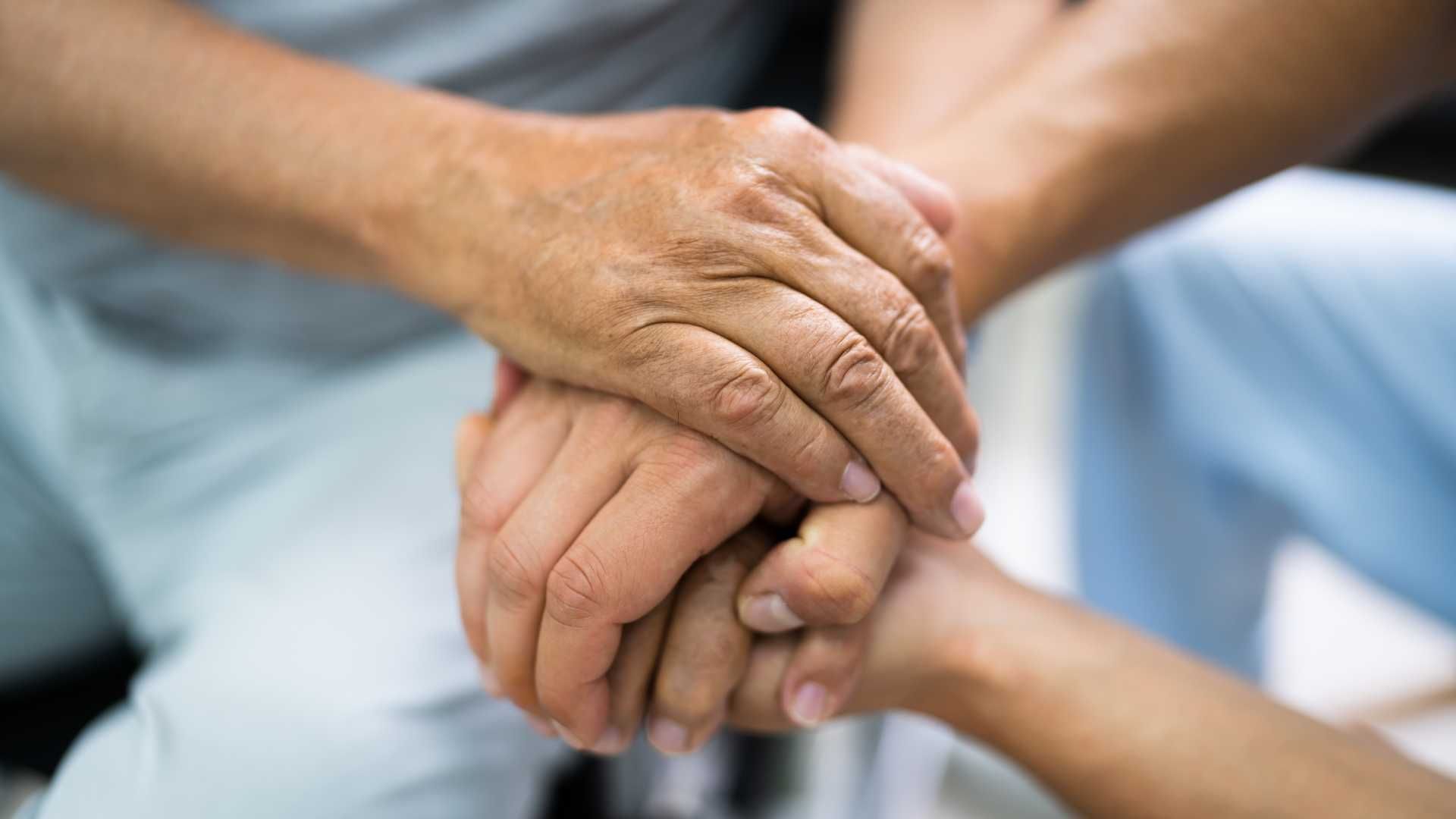 a close up of a person holding another person 's hand .