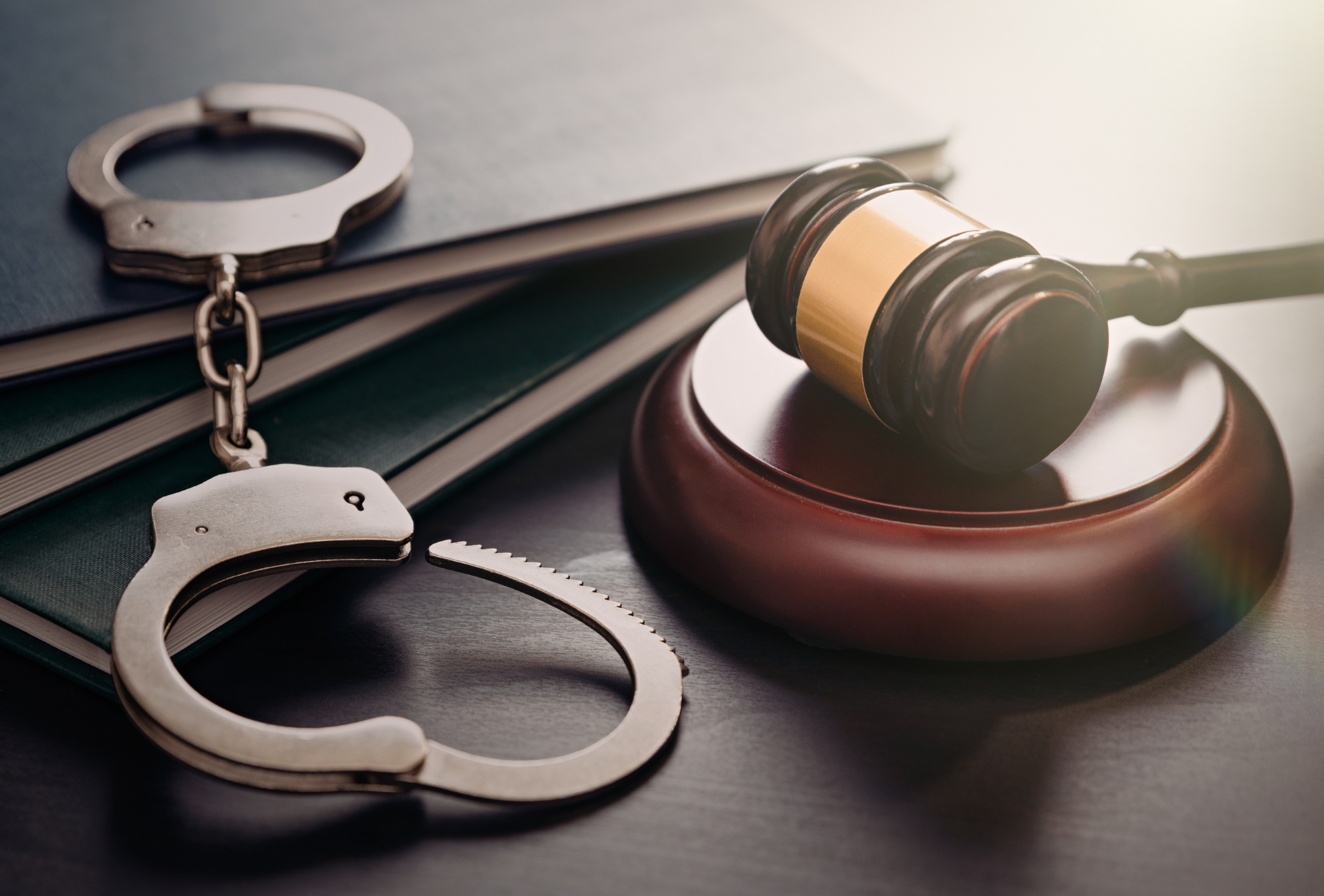 a pair of handcuffs and a judge 's gavel on a table .